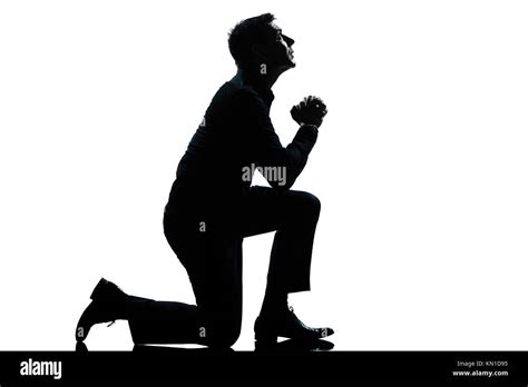 One Caucasian Man Kneeling Praying Full Length Silhouette In Studio