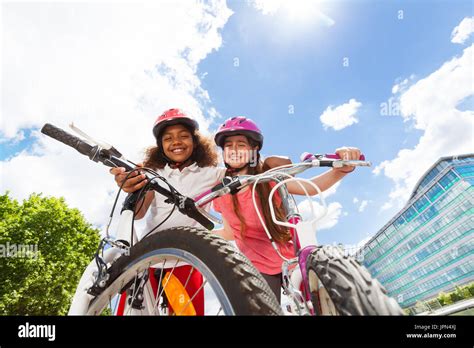 Happy Girl Friends Hugging And Holding Bicycles Stock Photo Alamy