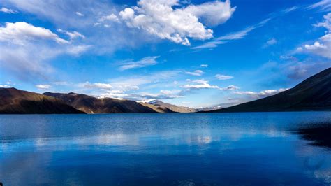 Download Wallpaper 1366x768 Lake Mountains Sunny Day Sky Clouds