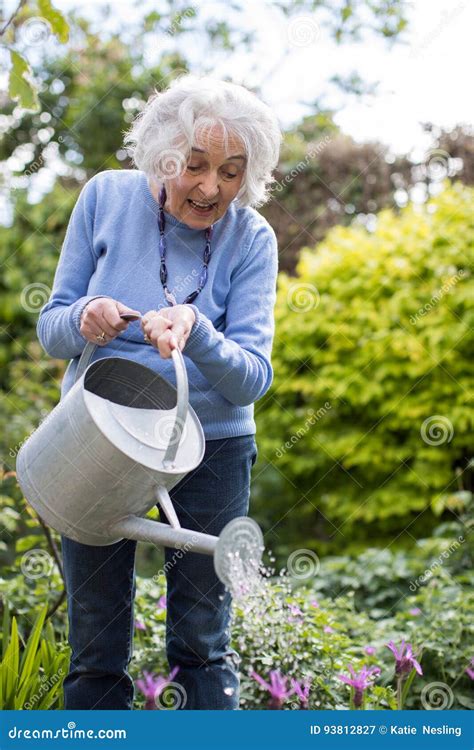 Senior Woman Watering Flowers In Garden Stock Image Image Of Happy