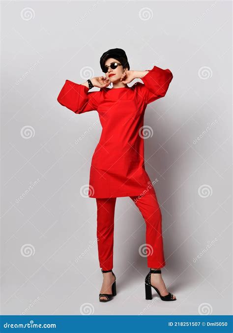 adult pretty sensual short haired brunette woman is posing in stylish casual red costume tunic
