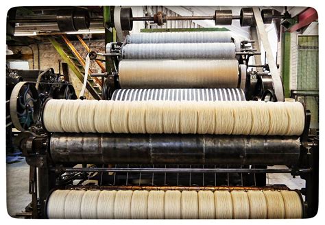Three Rolls Of Yarn On A Machine In A Factory