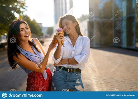 Two Young Female Friends Having Fun And Eating Ice Cream Cheerful Caucasian Women Eating