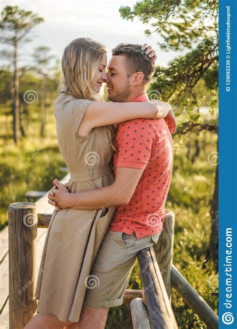 Side View Of Affectionate Couple Hugging On Wooden Bridge With Green Plants Stock Image Image