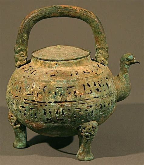 an old green teapot with a bird handle