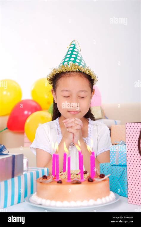 Girl Making Wish In Front Of Birthday Cake Stock Photo Alamy
