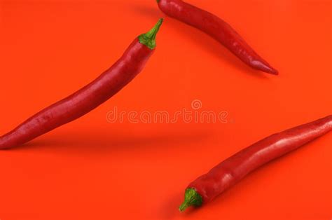 Three Red Hot Chili Peppers On A Red Background Popular Spices Stock