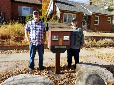 Two People Standing In Front Of A Mailbox