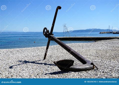 Large Iron Anchor Laid On The Pebble Shore By The Sea Stock Image