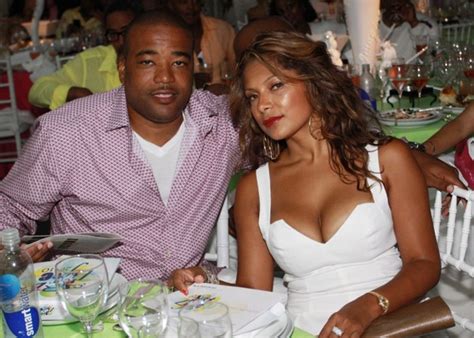 A Man Sitting Next To A Woman At A Table With Plates And Glasses On It