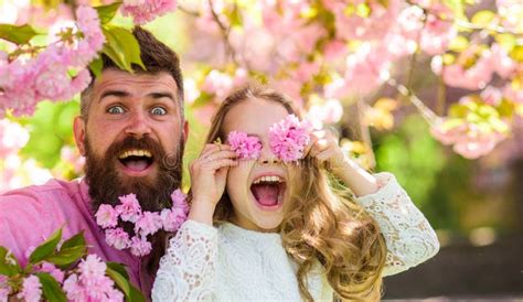 Father And Daughter On Happy Face Play With Flowers As Glasses Sakura