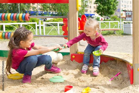 Conflict On The Playground Two Kids Fighting Over A Toy Shovel In The