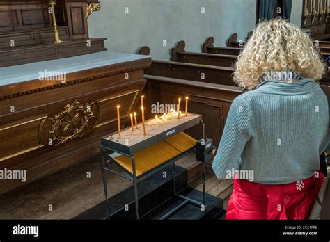 Woman Lighting A Candle In Church For Her Sins Stock Photo Alamy