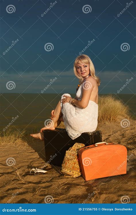 Menina Que Senta Se Em Uma Mala De Viagem Na Praia Imagem De Stock