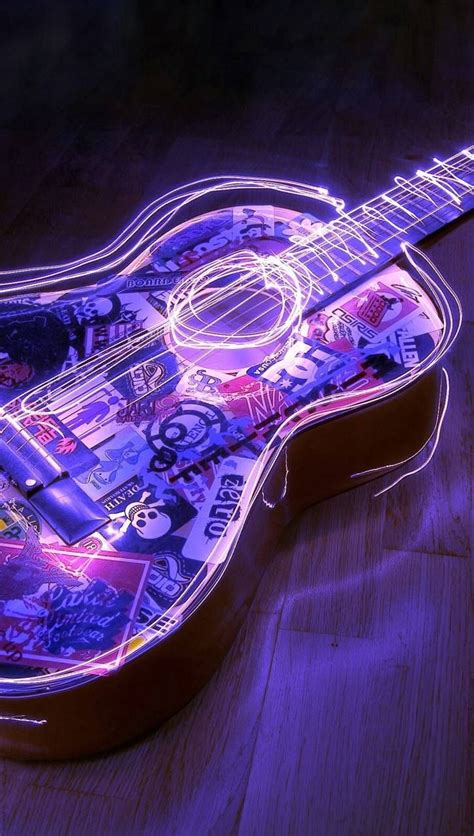 An Illuminated Guitar Sitting On Top Of A Wooden Table Next To A Purple