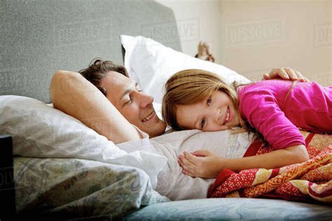 Babe Cuddling With Dad In Bed Stock Photo Dissolve