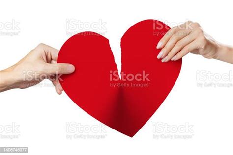 Male And Female Hands Tearing A Red Heart Symbol Of Love In Half On