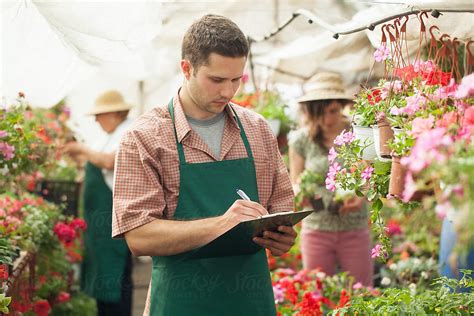 Nursery Garden Worker Listing Flowers By Stocksy Contributor Lumina