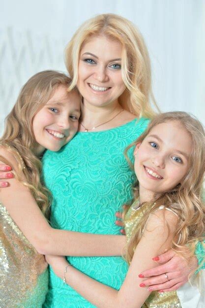 Premium Photo Cute Smiling Twin Sisters Hugging Their Mother