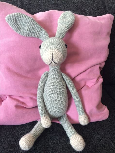 A Crocheted Bunny Sitting On Top Of A Pink Pillow