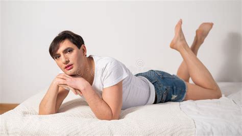Caucasian Transgender Man Lies On Gay Bed Outdoor Gay Posing In The Bedroom Stock Image