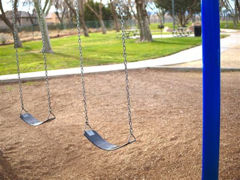 Empty Swing Set In Park With Blue Posts Stock Photo Image Of Grass