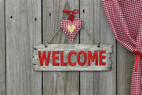 Red Welcome Sign Hanging On Wood Background With Gingham And Gold