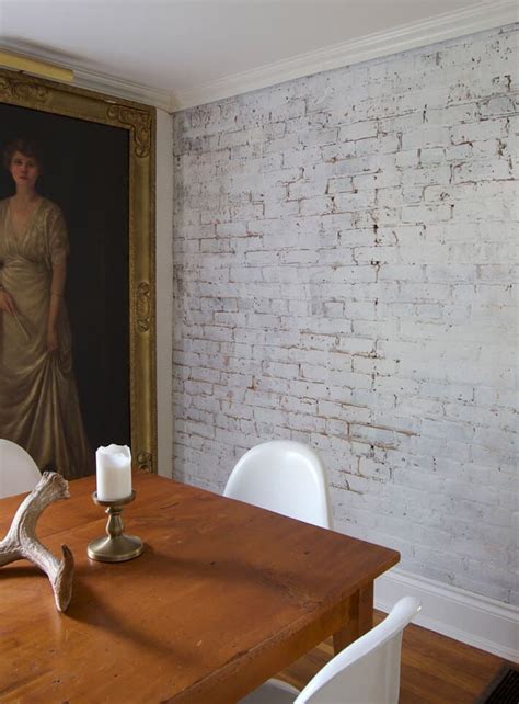 A Wooden Table With White Chairs And A Painting On The Wall In Front Of It