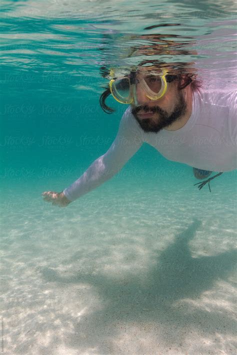 "Man Snorkeling Underwater In Tropics" by Stocksy Contributor "Jovana