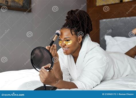 Side View On Nice African Woman Lying On Bed In Cozy Room With Golden