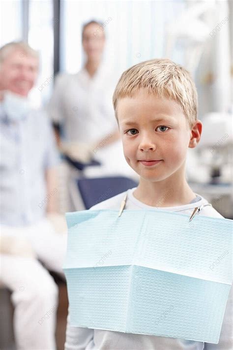 طفل متوهج في عيادة طب الأسنان صبي صغير رائعتين مبتهج وسط أطباء الأسنان في الخلفية صورة الخلفية