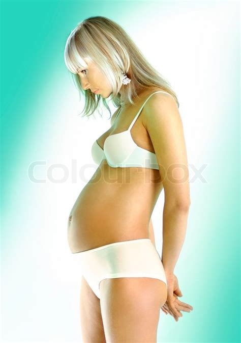 Smuk gravid kvinde i hvidt undertøj på lys baggrund stock foto