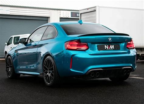 Weißer und blauer bmw m2 competition in der frontansicht stehen vor nächtlicher großstadtkulisse. NEW PROJECT!! - BMW M2 Competition | NV Motorsport UK
