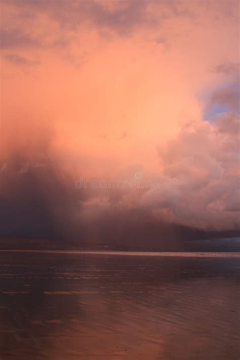 An Orange Grey Storm Cloud Builds And Moves Across The Beach
