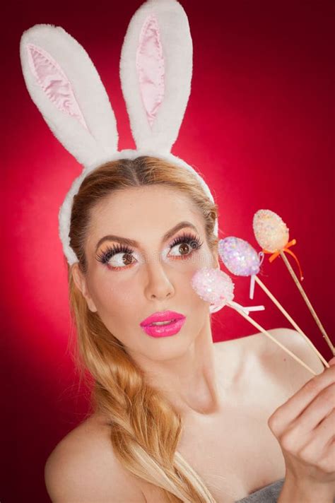 Beautiful Blond Woman As Easter Bunny With Rabbit Ears On Red