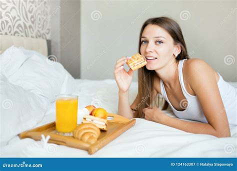 Beautiful Brunette Girl Eating A Healthy Breakfast In Bed Stock Image
