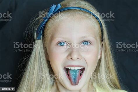 Headshot Portrait Of Teenage Blonde Girl With Sticking Out Tongue Stock