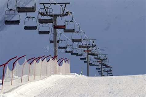 Snowy Ski Slope And Chair Lift On High Mountains At Sunny Winter