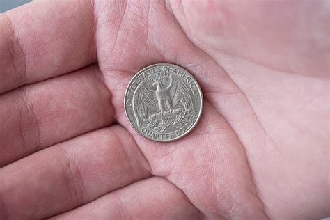 Premium Photo A Man Holding Silver American Quarter Dollar Coin 25