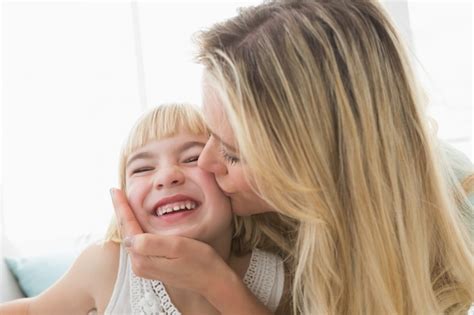 Madre Besando A Hija Feliz En La Mejilla Foto Premium