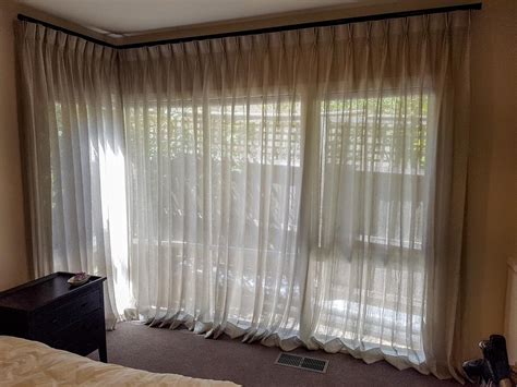 Pinch Pleated Sheer Curtains Pooled On Floor With Decorator Pole And