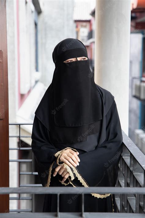 premium photo portrait of arabian woman looking outdoor while covering her face with niqab