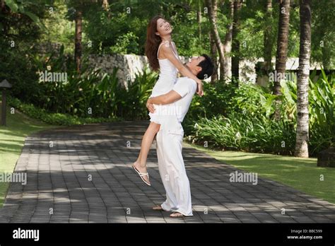 Couple In Garden Man Carrying Woman Stock Photo Alamy