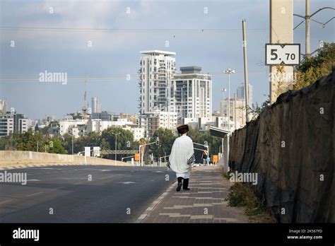 Orthodox Jewish Man In A Prayer Shawl Walking In The Empty Street On