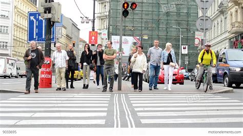 Pedestrians Waiting At Traffic Lights Busy Urban Street With Cars In
