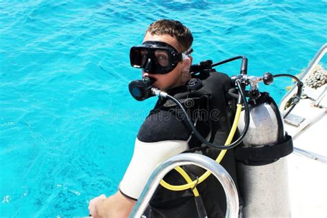 Scuba Diver Is Preparing For Diving Into Blue Water From The Boat