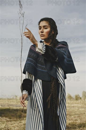 Caucasian Woman Wearing Traditional Clothing Examining Twig Photo12 Tetra Images Ivan Ozerov