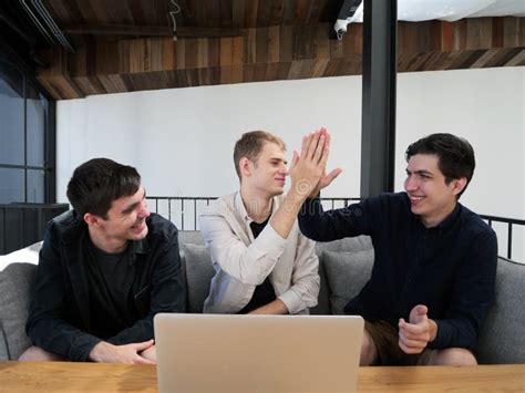 Three Happy Freelance Men Working Together In Co Working Space Stock