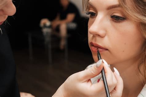 Premium Photo Shooting In A Beauty Salon Makeup Artist Applies Makeup To A Young Beautiful