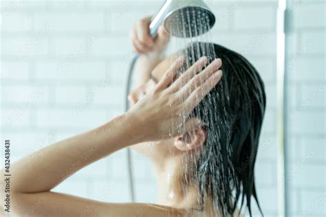 シャワーを浴びる女性 Photos Adobe Stock